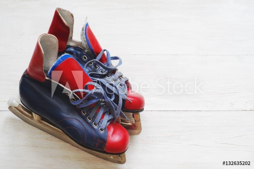 Picture of Vintage pair of mens ice skates on a white wooden surface